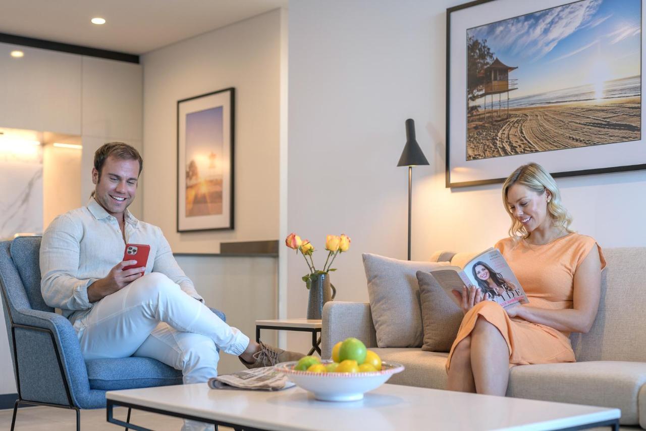 Meriton Suites Surfers Paradise Gold Coast Bagian luar foto A couple reading a magazine in their living room